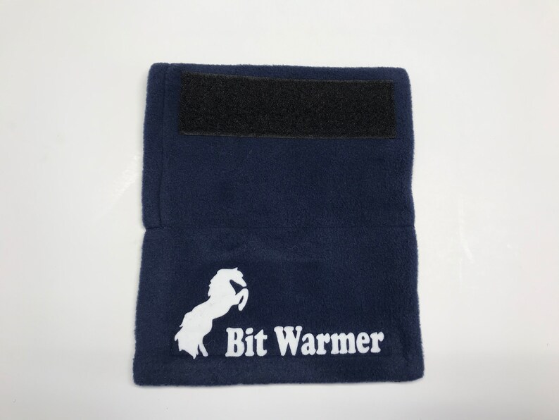 May include: A navy blue fleece bit warmer with a white horse logo and the text "Bit Warmer". The warmer has a black velcro strap.