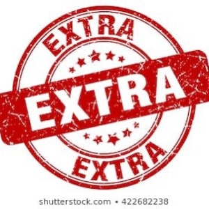 May include: A red circular stamp with the word "EXTRA" in white, repeated three times. The stamp has a distressed, worn appearance, with visible texture and a faded look. The word "EXTRA" is also printed on a rectangular banner across the center of the stamp.