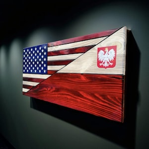 May include: A rectangular wooden wall art piece featuring a split design. The left side displays the blue field with white stars and red and white stripes of the American flag. The right side shows the white eagle emblem of Poland on a red background.