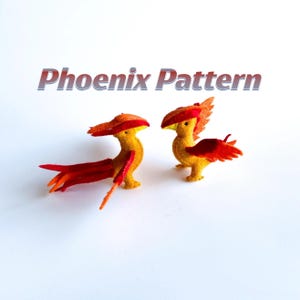May include: Two small felt phoenix figurines in vibrant yellow and red colors. The birds feature long, flowing tail feathers and detailed wing structures. The text Phoenix Pattern is displayed in a bold, stylized font above the two figures.