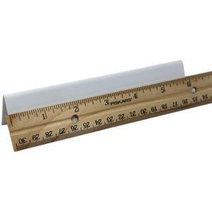 May include: A white, angled trim piece is positioned next to a wooden ruler. The ruler, marked with black increments, measures up to 30 inches. The trim piece appears to be made of a solid, opaque material.