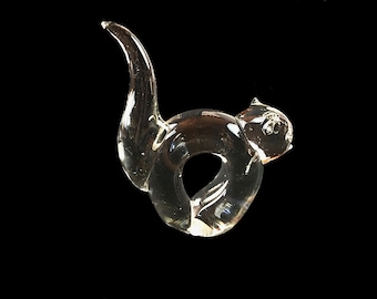 Peut inclure: Une sculpture de chat en verre transparent enroulée en cercle. La sculpture est en verre soufflé et a une finition lisse et polie.