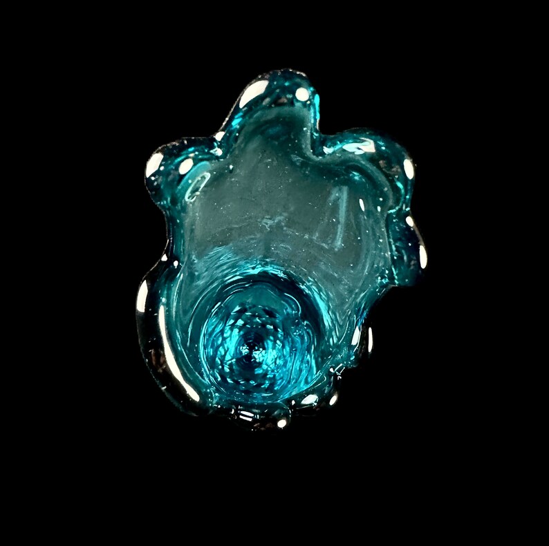 Pode incluir: Um vaso de vidro azul turquesa com uma forma org&acirc;nica &uacute;nica. O vaso tem uma abertura larga e uma base estreita.