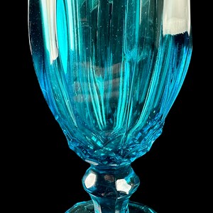 Pode incluir: Um c&aacute;lice de vidro azul turquesa com um design canelado. O vidro &eacute; transparente e tem uma superf&iacute;cie texturizada.