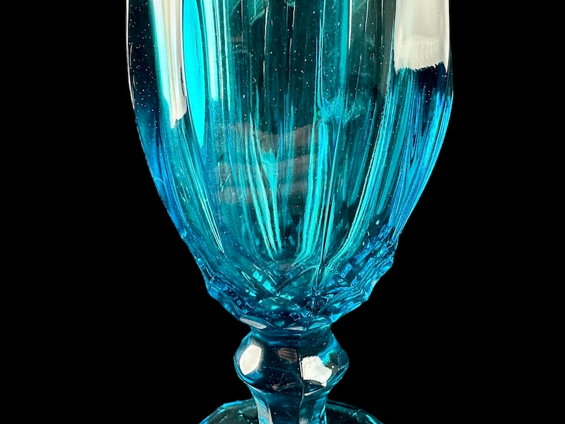 Pode incluir: Um c&aacute;lice de vidro azul turquesa com um design canelado. O vidro &eacute; transparente e tem uma superf&iacute;cie texturizada.