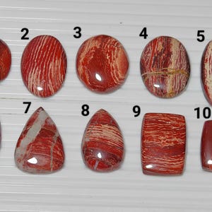 May include: Ten red and white striped agate cabochons, numbered 1 through 10. The cabochons are various shapes and sizes.