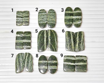 Puede incluir: Diez pares de cabujones rayados en verde y blanco, numerados del 1 al 10. Los cabujones son de forma ovalada y rectangular.