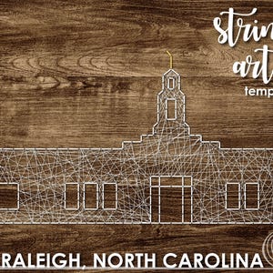 May include: String art template of the Raleigh, North Carolina skyline. The template is a white outline of the city's buildings on a brown wood background.