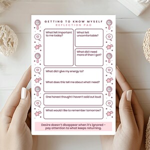 May include: A pink and white reflection pad with the text "GETTING TO KNOW MYSELF" and prompts for self-reflection. The pad includes prompts such as "What felt important to me today?" and "What felt uncomfortable?"