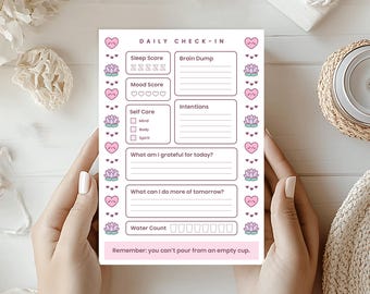 Puede incluir: Un bloc de notas "Daily Check-In" con un diseño rosa y blanco. Incluye secciones para el sueño, el estado de ánimo, el autocuidado, la gratitud y las intenciones. Elementos decorativos: corazones y flores de loto. El texto dice: "Remember: you can't pour from an empty cup."