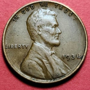 May include: A copper-colored 1938 Lincoln penny. The obverse features a profile of Abraham Lincoln, with the words "IN GOD WE TRUST" and "LIBERTY" inscribed. The year "1938" is also visible.
