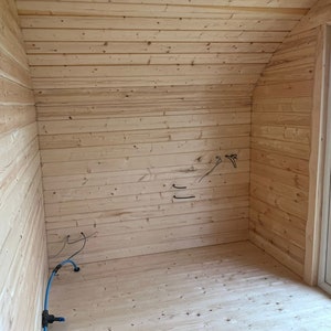 Puede incluir: Una habitaci&oacute;n vac&iacute;a con paneles de madera en las paredes y el techo. El suelo tambi&eacute;n es de madera. Hay algunos cables el&eacute;ctricos y una manguera azul que recorren la pared.