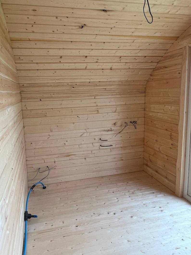 Puede incluir: Una habitaci&oacute;n vac&iacute;a con paneles de madera en las paredes y el techo. El suelo tambi&eacute;n es de madera. Hay algunos cables el&eacute;ctricos y una manguera azul que recorren la pared.