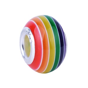 Puede incluir: Un abalorio de encanto rayado de arcoíris con un anillo de metal plateado. El abalorio está hecho de vidrio y tiene un acabado brillante.