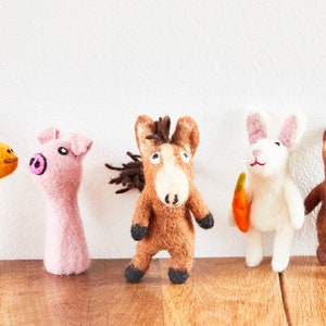 Könnte beinhalten: Fünf Fingerpuppen aus Filz, jede zeigt ein anderes Tier: eine Giraffe, ein Schwein, ein Pferd, ein Kaninchen und ein Bär. Die Puppen sind braun, rosa, orange, weiß und braun.