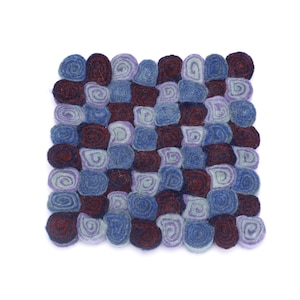 Könnte beinhalten: Ein quadratischer, handgefertigter Filz-Topfuntersetzer mit Mosaikmuster. Das Design zeigt ein Gitter aus kleinen, gerollten Filzstücken in Blau-, Lila- und Burgundertönen. Schützt Oberflächen vor heißen Töpfen.