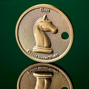 May include: A gold-coloured metal coin with a knight chess piece on one side and the words "Chess Choose Moves Wisely" on the other side.