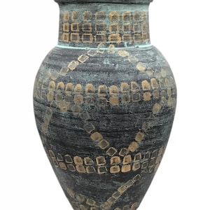 May include: A decorative vase with a dark gray and gold geometric pattern. The vase has a wide body and a narrow neck. The surface has a textured appearance with a distressed finish. The vase is suitable for home decor.
