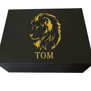 May include: Black gift box with a gold lion head design and the word "TOM" embossed on the front.