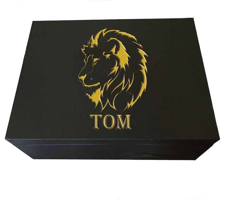 May include: Black gift box with a gold lion head design and the word "TOM" embossed on the front.