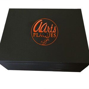 May include: Black box with a red circle logo that says "Arts Plaques" in a cursive font.