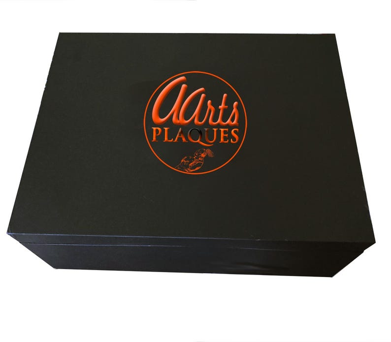 May include: Black box with a red circle logo that says "Arts Plaques" in a cursive font.