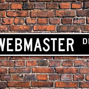 Może przedstawiać: Czarno-biały znak ulicy z napisem "WEBMASTER DR." na tle ceglanego muru.