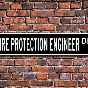 Op de afbeelding: Zwart-wit straatnaambord met de tekst "FIRE PROTECTION ENGINEER DR."