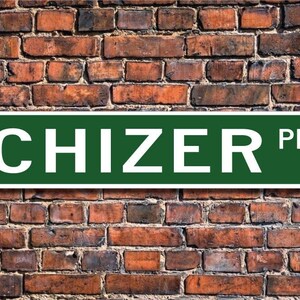 Puede incluir: Un cartel de calle verde con letras blancas que dice "CHIZER PL."