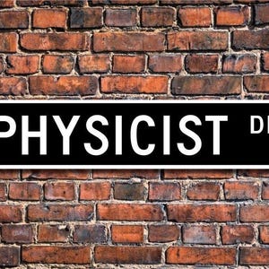 Puede incluir: Un letrero de calle blanco y negro con el texto "PHYSICIST DR." en letras blancas sobre fondo negro.