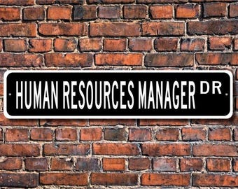 May include: Black and white sign with the text "HUMAN RESOURCES MANAGER DR." on a brick wall background.