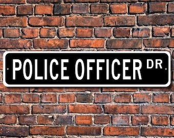 May include: Black and white street sign with the text "POLICE OFFICER DR." on a brick wall background.