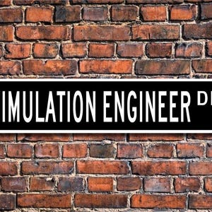 May include: Black and white street sign with the text "SIMULATION ENGINEER DR." on a brick wall background.