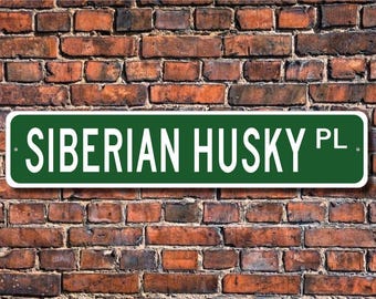 Könnte beinhalten: Ein grünes Straßenschild mit weißen Buchstaben, auf dem "SIBERIAN HUSKY PL." steht.