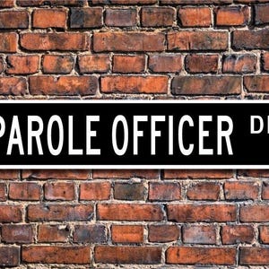 May include: Black and white street sign with the text "PAROLE OFFICER DR."