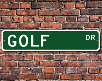 May include: A green and white street sign with the text "GOLF DR." on a brick wall background.