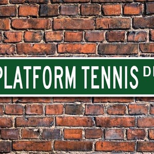 May include: Green street sign with white lettering that reads "PLATFORM TENNIS DR."