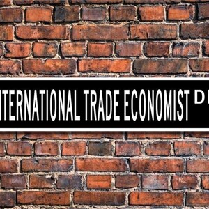 Könnte beinhalten: Schwarz-weißes Schild mit dem Text "INTERNATIONAL TRADE ECONOMIST DR." vor einem Hintergrund aus Ziegelmauer.
