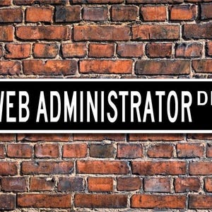 May include: Black and white street sign with the text "WEB ADMINISTRATOR DR." on a brick wall background.