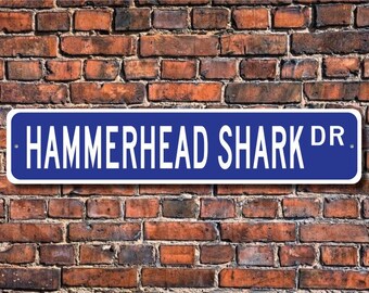 May include: Blue street sign with white text that reads "HAMMERHEAD SHARK DR."