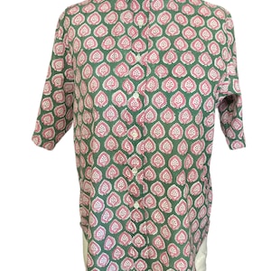 May include: Green button-down shirt with a repeating pattern of pink and white leaf-like shapes. The shirt has a classic collar and three-quarter sleeves. The fabric appears to be lightweight.