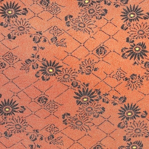 Puede incluir: Una tela roja con un patrón floral negro. El patrón está formado por pequeñas flores y hojas repetidas. La tela tiene una superficie texturizada.