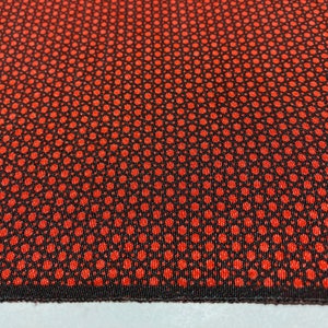 May include: Red and black fabric with a repeating pattern of small red circles on a black background.