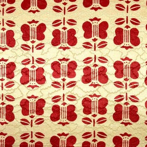 Peut inclure: Motif floral rouge répété sur un fond crème. Les fleurs ont une forme stylisée et symétrique avec des lignes verticales au centre. Le fond présente un aspect subtil et texturé.