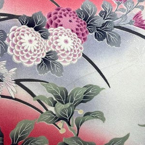 May include: Close-up of a floral pattern featuring large, layered flowers in shades of pink and white, accented by gray leaves and stems. The background transitions from red to light blue and white, creating a soft, artistic effect.