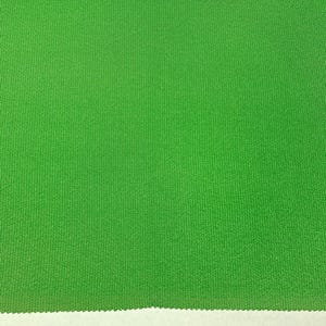 Puede incluir: Una tela verde brillante con una superficie texturizada y acanalada.