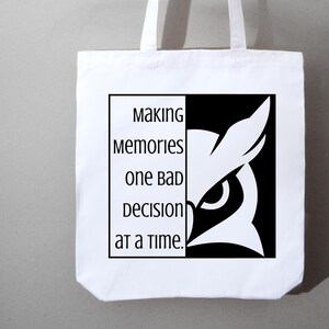 May include: White tote bag with black and white graphic. The graphic features an owl design and the text "Making Memories One Bad Decision at a Time." The bag has two white handles.