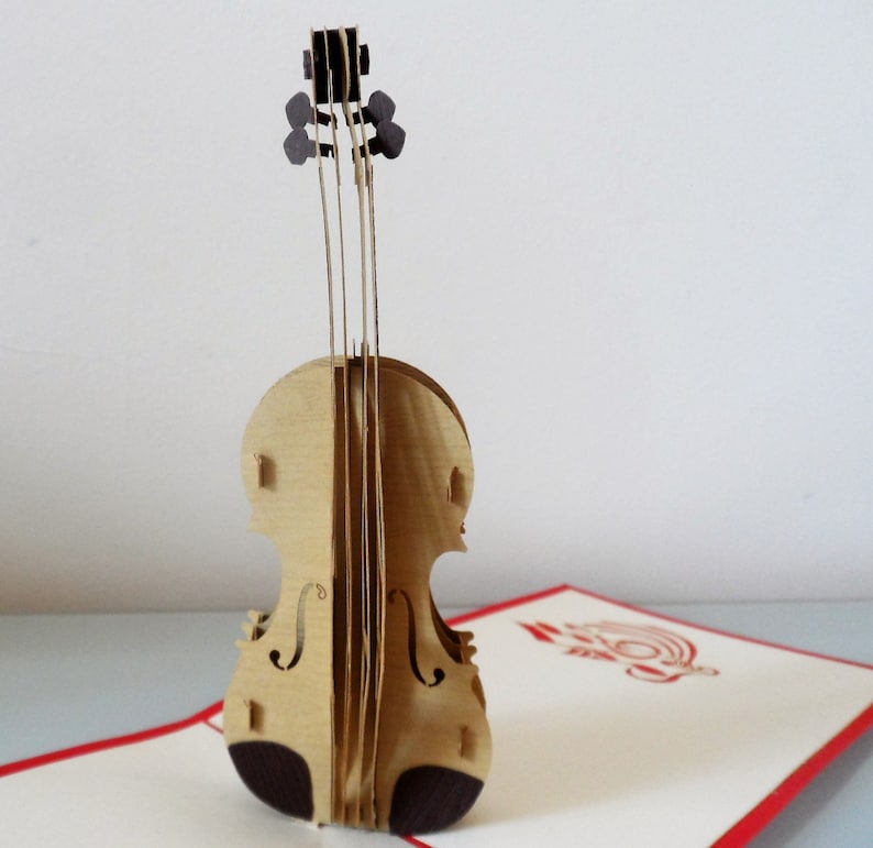 May include: A brown wooden pop-up card of a violin. The violin is intricately detailed and has a realistic appearance.