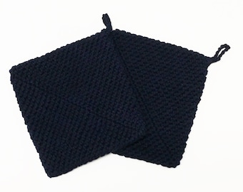 May include: Two navy blue, square-shaped potholders. Each potholder is made of a thick, knitted material and has a small loop at one corner for hanging. The potholders are designed for kitchen use.