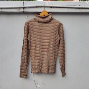 May include: A brown and beige striped long-sleeved turtleneck sweater.
